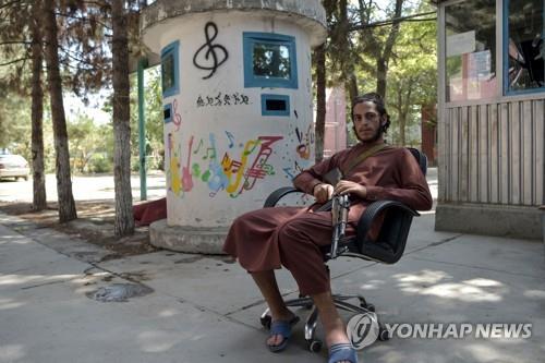 아프간 국립 음악원에 총 들고 앉아있는 탈레반 대원