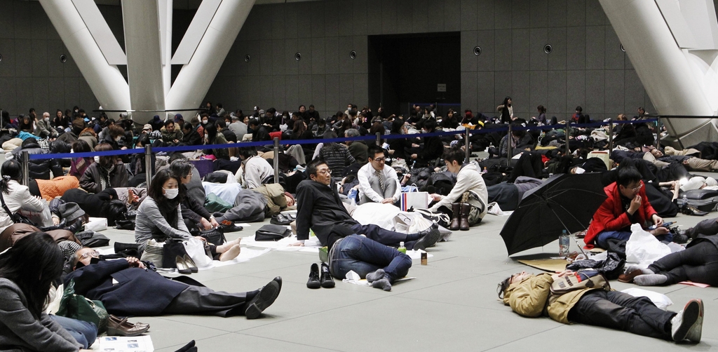 (도쿄 교도=연합뉴스) 동일본대지진 발생 다음 날인 2011년 3월 12일 오전 일본 도쿄도(東京都) 소재 시설인 도쿄국제포럼에서 귀가하지 못한 이들이 휴식을 취하고 있다.