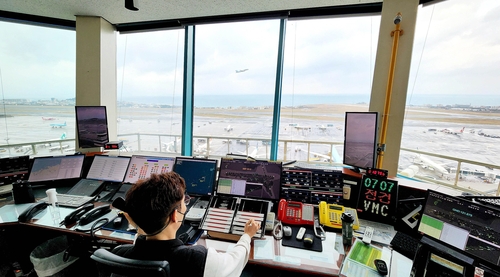 날아오르는 항공기와 제주공항 관제탑
