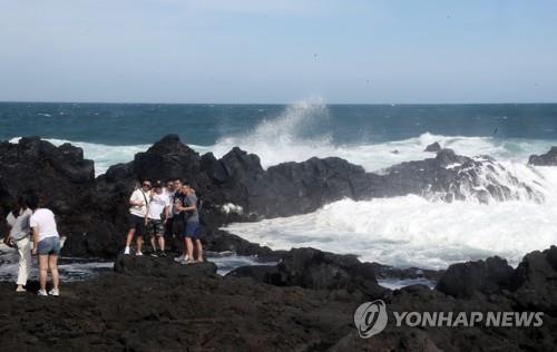 Esta foto de archivo muestra a las personas tomando fotos en una playa de la isla de Jeju.