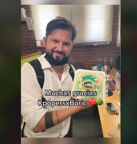 La foto, capturada de un vídeo publicado en la cuenta de TikTok del presidente electo de Chile, Gabriel Boric Font, muestra a Boric sosteniendo una tarta que recibió de fanes chilenos del K-pop que lo apoyan. (Prohibida su reventa y archivo)