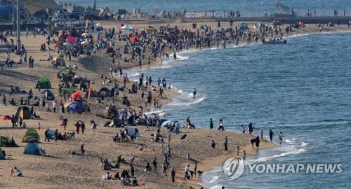 La foto, tomada el 5 de mayo de 2022, muestra una playa abarrotada de personas, en la ciudad costera oriental de Sokcho, en la provincia de Gangwon.