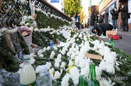 Una persona se arrodilla, el 31 de octubre de 2022, en un sitio para rendir tributo a las víctimas de la estampida humana ocurrida, el 29 de octubre, en el barrio de Itaewon, en el centro de Seúl, durante las celebraciones de Halloween.