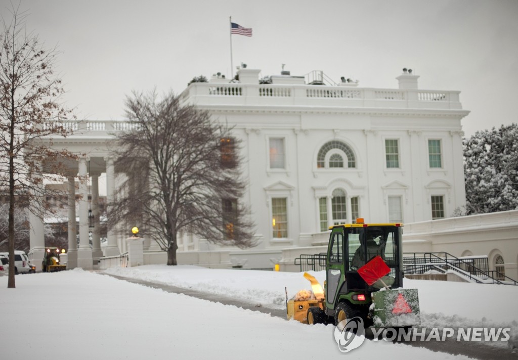 17일(현지시간) 워싱턴DC에 큰 눈이 내려 백악관에 쌓인 눈을 제설차량이 치우고 있다 (AP=연합뉴스)