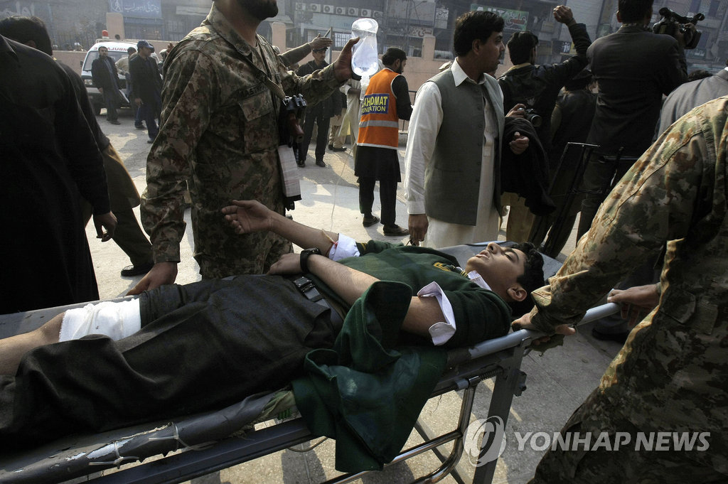 16일(현지시간) 파키스탄 페샤와르에서 탈레반의 테러 공격에 다친 학생이 병원으로 옮겨지고 있다.(AP=연합뉴스)