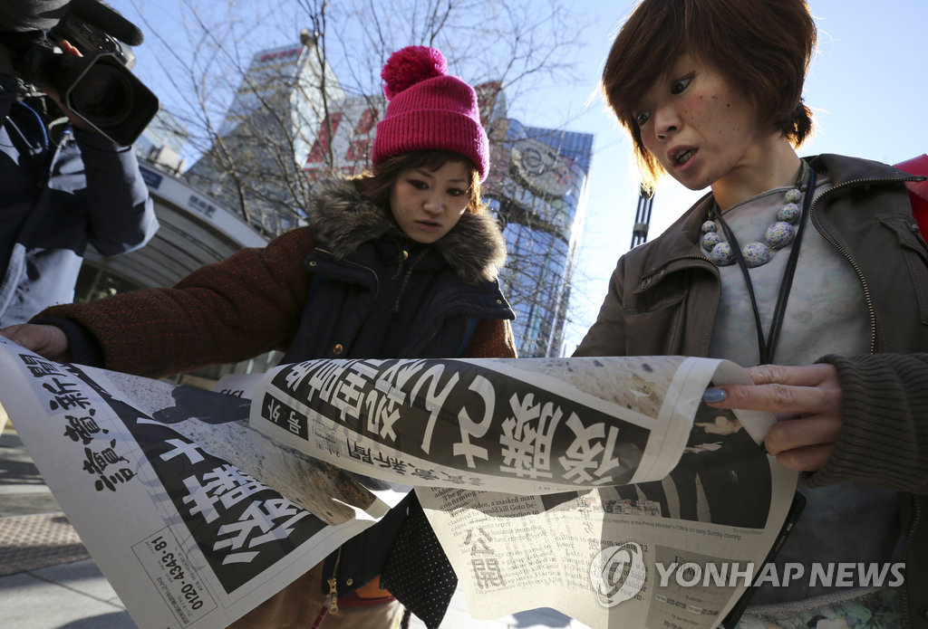 일본 여성들이 도쿄 시내에서 고토 겐지(後藤健二·47)의 참수 소식이 담긴 호외 신문을 보고 있다. (AP=연합뉴스)