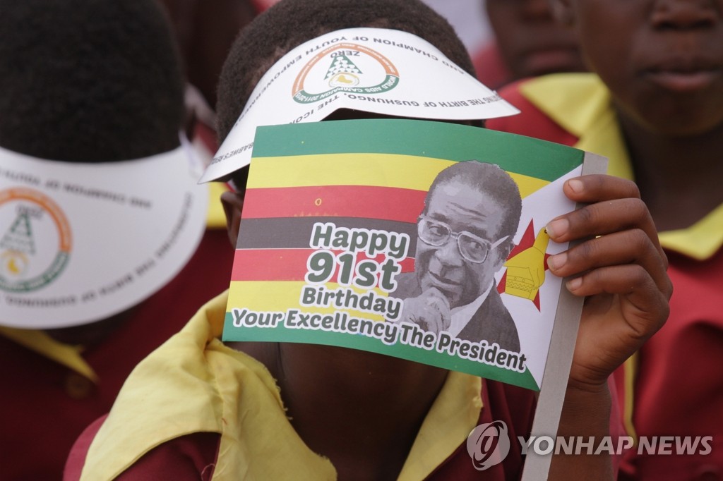 지난달 28일 열린 로버트 무가베 짐바브웨 대통령의 생일 축하 연회에서 한 소년이 생일 축하 깃발을 들고 있다.(AP=연합뉴스)