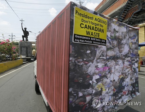 2015년 3월 4일 필리핀 마닐라 대통령 궁 앞에서 캐나다의 유해 폐기물 수출에 항의하는 국제 환경보호단체 그린피스의 시위 현장에 당시 촬영된 폐기물의 사진이 붙은 컨테이너가 세워져 있다. [AP=연합뉴스자료사진]