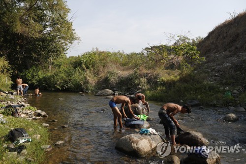 개울에서 목욕하고 빨래하는 중미 이민자들