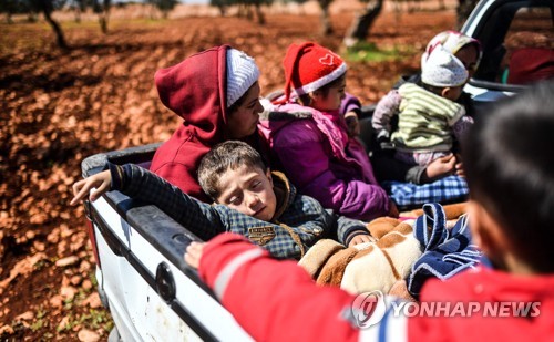 트럭 짐칸에 타고 피란 가는 시리아 쿠르드 아이들