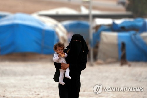 시리아 북동부 난민 캠프의 한 여성과 아이