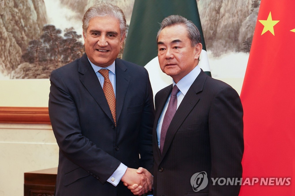 왕이 중국 외교부장과 샤 메흐무드 쿠레시 파키스탄 외교장관이 19일 베이징에서 만나 악수하고 있다. [AFP=연합뉴스]