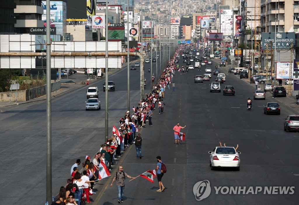 27일(현지시간) 레바논 반정부 시위자들이 국토를 남북으로 가로지르는 170km 길이의 인간띠를 만들었다.