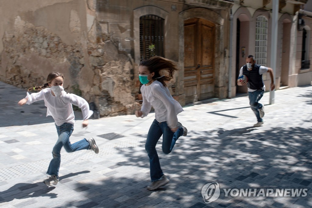 스페인에서 어린이 외출이 허용된 26일 바르셀로나 시내에서 어린이들이 아빠와 함께 뛰어놀고 있다. [AFP=연합뉴스]