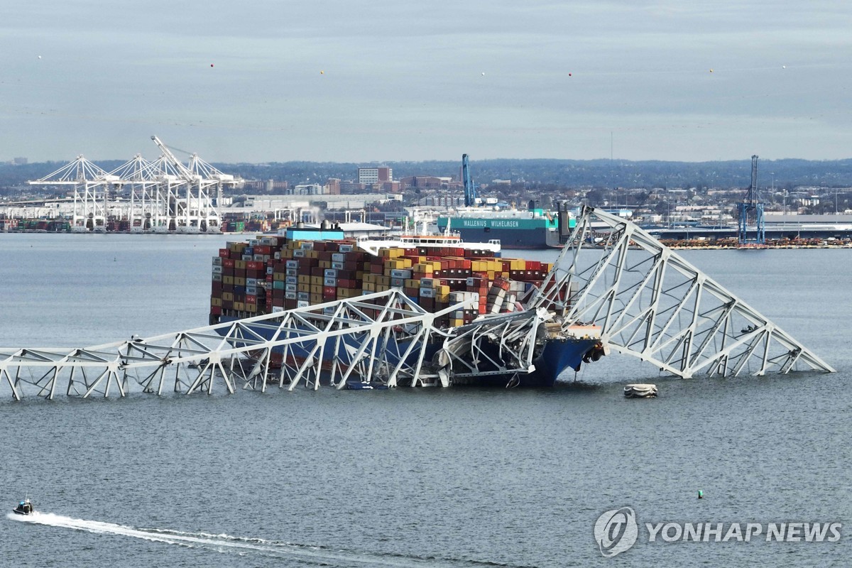 The steel frame of the Francis Scott Key Bridge sits on top of a container ship after the bridge collapsed in Baltimore, Maryland, on March 26, 2024 in this photo released by AFP. (Yonhap)
