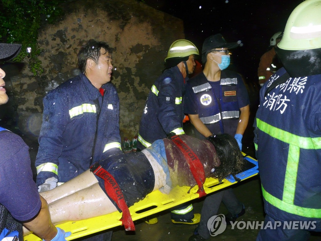 대만 소방대원들이 비행기 추락사고로 부상을 당한 한 여성을 구조하고 있다. (EPA=연합뉴스)