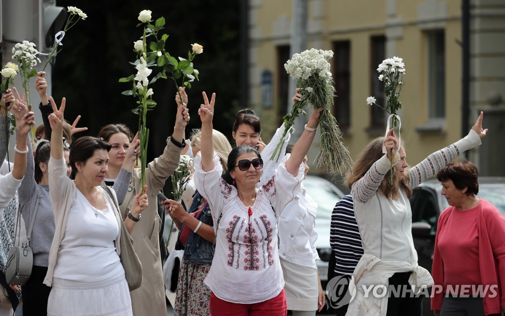 (EPA=연합뉴스) 벨라루스 여성들이 13일(현지시간) 민스크 시내에서 시위에 참가했다가 체포된 사람들에 대한 연대의 표시로 흰 장미를 들고 항의 집회를 열고 있다. 