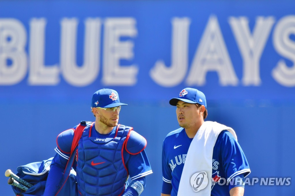 In this Getty Images file photo from March 5, 2021, Toronto Blue Jays' pitcher Ryu Hyun-jin (R) and his catcher, Danny Jansen, walk out to the field at TD Ballpark in Dunedin, Florida, before a major league spring training game against the Baltimore Orioles. (Yonhap)