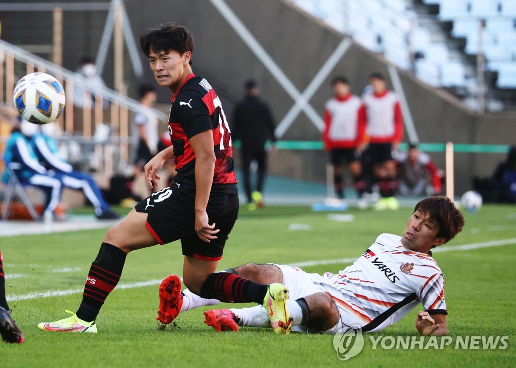 In this Reuters photo, Go Young-joon of Pohang Steelers (L) is tackled by Yasuki Kimoto of Nagoya Grampus during the clubs' quarterfinal match at the Asian Football Confederation Champions League at Jeonju World Cup Stadium in Jeonju, 240 kilometers south of Seoul, on Oct. 17, 2021. (Yonhap)