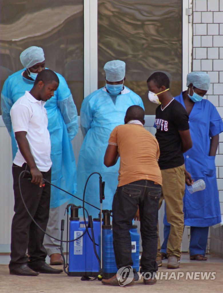 기니 수도 코나크리의 한 병원 입구에서 의료진이 병원을 찾아온 에볼라 바이러스 감염 의심 환자들의 상태를 살피고 있다. (AP=연합뉴스 자료사진)