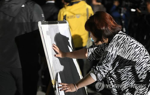 16일 오후 전남 진도군 팽목항에서 이날 오전 침몰한 여객선 세월호 실종자 가족이 애타게 구조자 명단을 확인하고 있다.