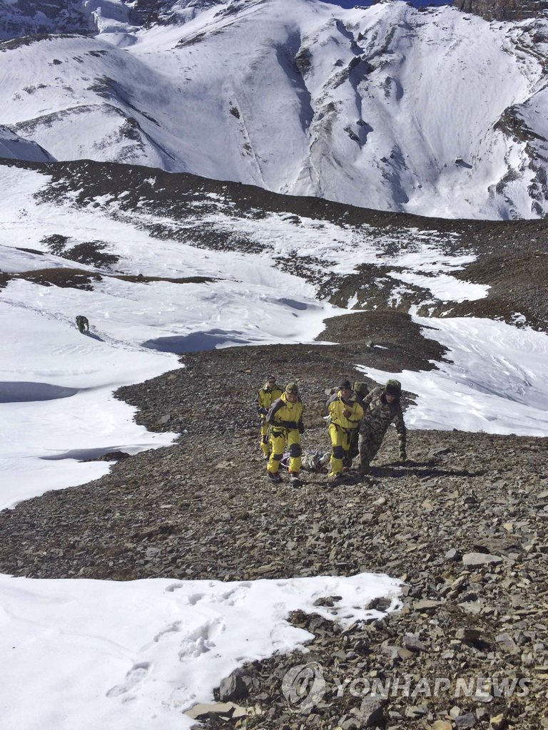 16일(현지시간) 네팔 히말라야의 쏘롱라 고개(해발 5천461m)에서 구조대원들이 눈사태로 숨진 희생자의 시신을 헬기가 있는 곳으로 끌고가고 있다. (AP=연합뉴스)