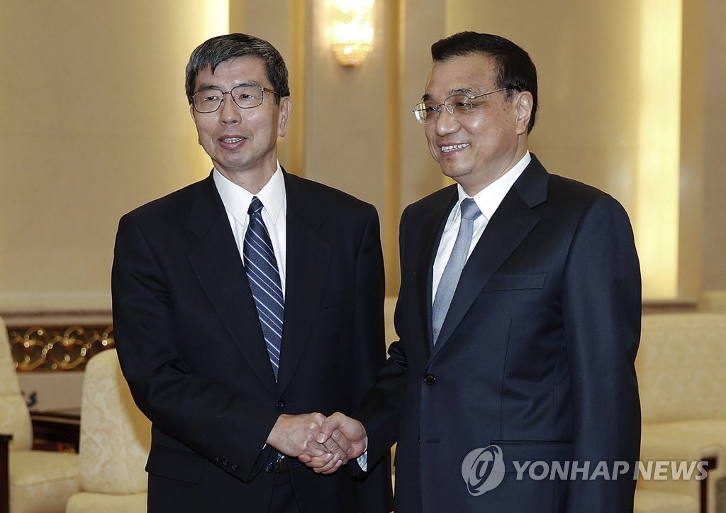 (AP=연합뉴스) 베이징(北京)의 중국발전고위급 포럼에 참석 중인 나카오 타케히코(왼쪽) 아시아개발은행(ADB) 총재가 2015년 3월 23일 베이징 인민대회당에서 리커창 중국 총리와 만나 악수하고 있다.