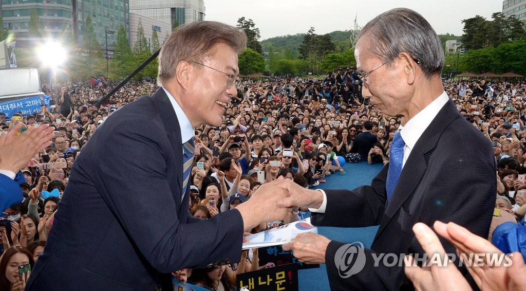 (고양=연합뉴스) 배재만 기자 = 더불어민주당 문재인 대선 후보(왼쪽)가 4일 오후 경기 고양시 일산 문화광장에서 열린 집중유세에서 한승헌 전 감사원장에게 통합정부추진위 제안서를 전달받고 있다. 2017.5.4 scoop@yna.co.kr