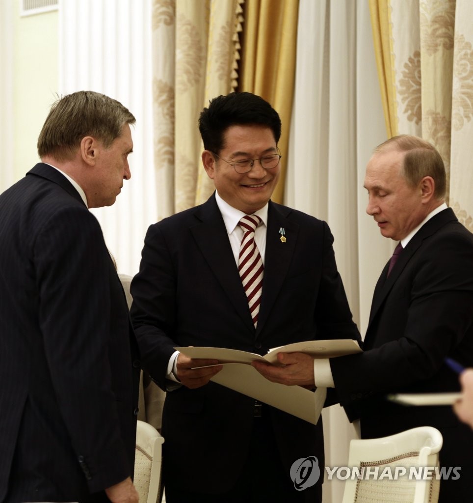 プーチン大統領（右端）に文在寅大統領の親書を手渡す宋永吉議員（中央）＝２４日、モスクワ（聯合ニュース）