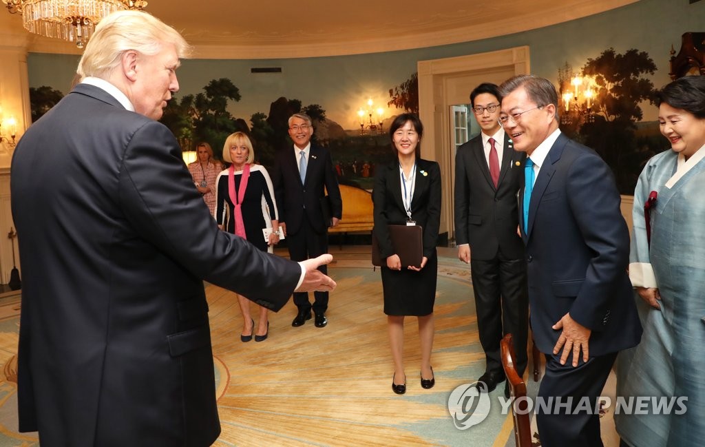 握手を交わすため文大統領（手前右）に手を差し出すトランプ大統領＝２９日、ワシントン（聯合ニュース）