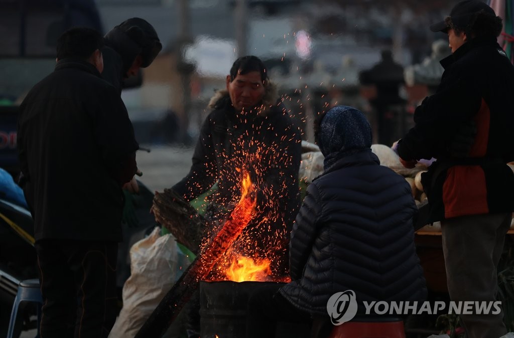 불에 몸 녹이는 상인들