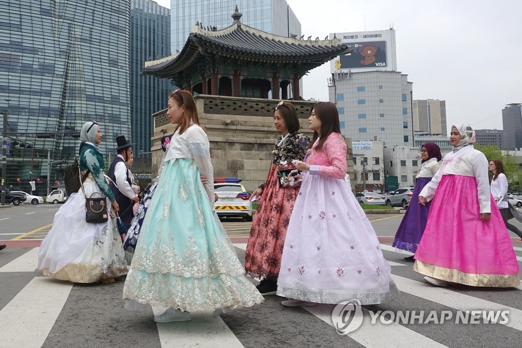 韓国の伝統衣装「韓服」を着てソウル市内を歩く外国人観光客＝（聯合ニュース）