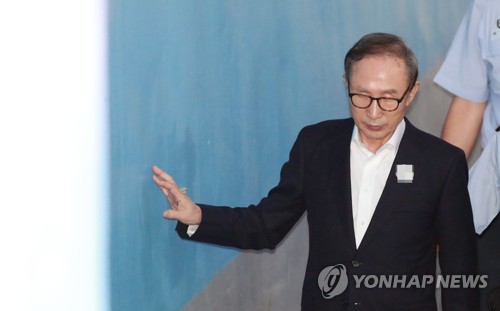 벽에 손대며 공판 출석하는 이명박