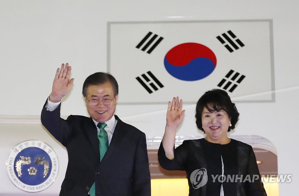 밝은 표정으로 귀국한 문 대통령 부부