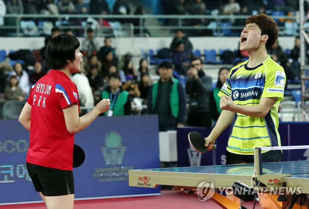 Cha Hyo-sim of North Korea (L) and Jang Woo-jin of South Korea celebrate their point over Lim Jong-hoon and Yang Ha-eun of South Korea during the mixed doubles semifinals at the International Table Tennis Federation World Tour Grand Finals on Dec. 14, 2018, at Namdong Gymnasium in Incheon, 40 kilometers west of Seoul. (Yonhap)