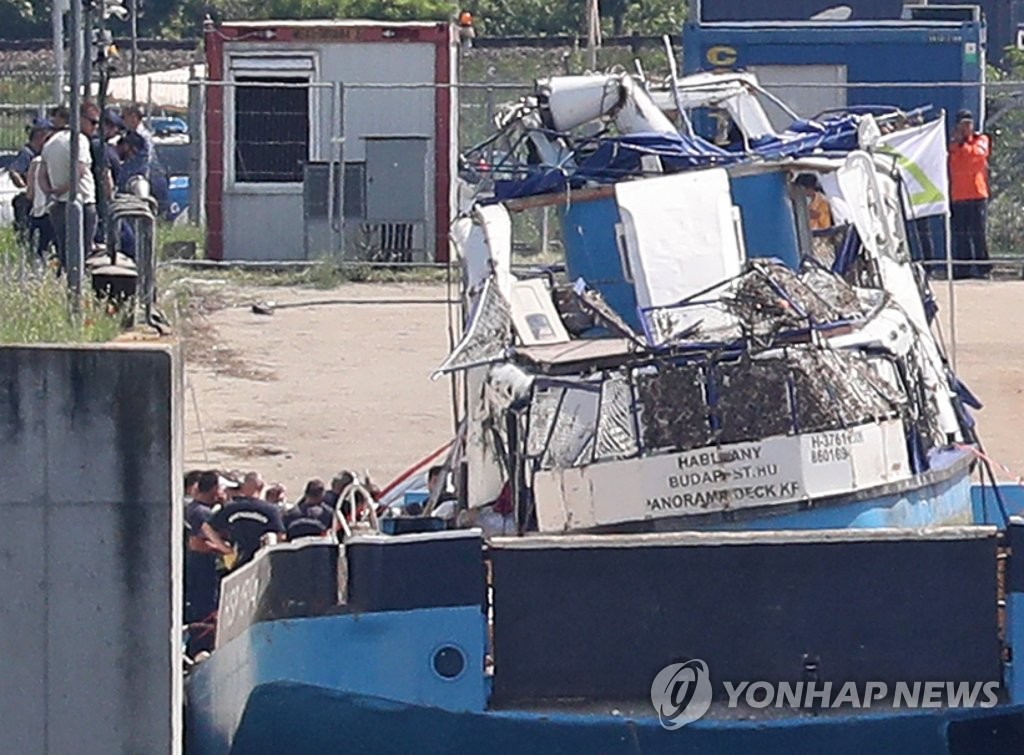 Officials gather near a quay at which the salvaged tour boat Hableany is docked, on June 12, 2019, after it was raised and transported on a barge to an island south of Budapest in Hungary. (Yonhap) 