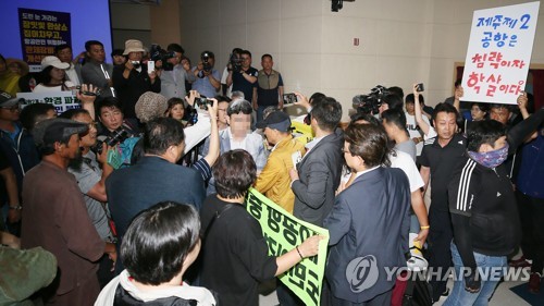 반대 단체에 둘러싸인 용역진