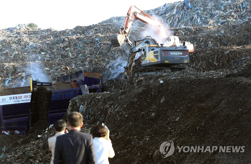 '쓰레기 산' 처리 현장 점검하는 정부·지자체 관계자