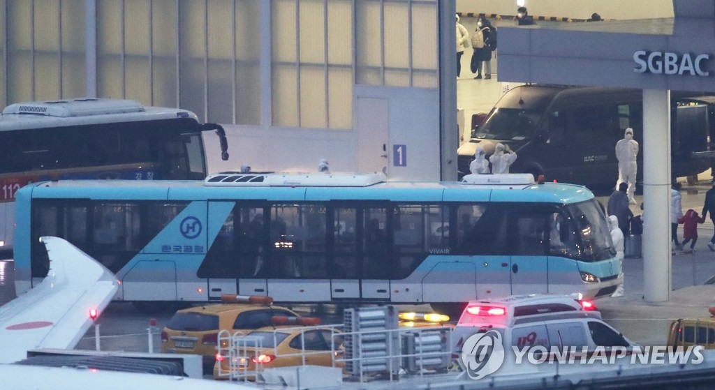 チャーター機でソウルの金浦空港に到着後、バスで移動する帰国者＝１２日、ソウル（聯合ニュース）