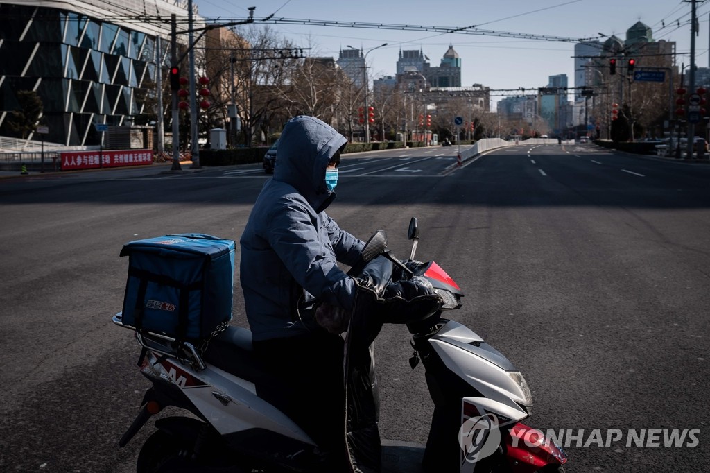 인적 드문 베이징 도로를 달리는 택배원