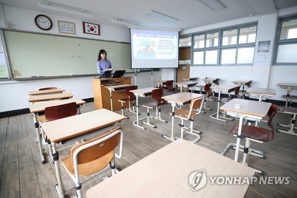텅 빈 교실에서 온라인 강의 연습하는 교사