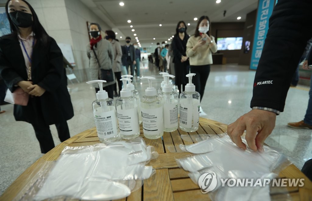 Standing 1 meter apart from each other, voters wait in line at a polling station in Daejeon, 164 kilometers south of Seoul, on April 10, 2020, to cast ballots in early voting for the April 15 elections. (Yonhap)