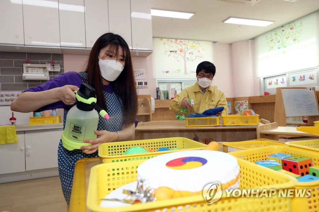 A teacher and a government official disinfect toys and teaching materials at a child care center in Gwangju, 329 kilometers southwest of Seoul, on June 1, 2020, following the suspension of its operation over the new coronavirus. (Yonhap) 