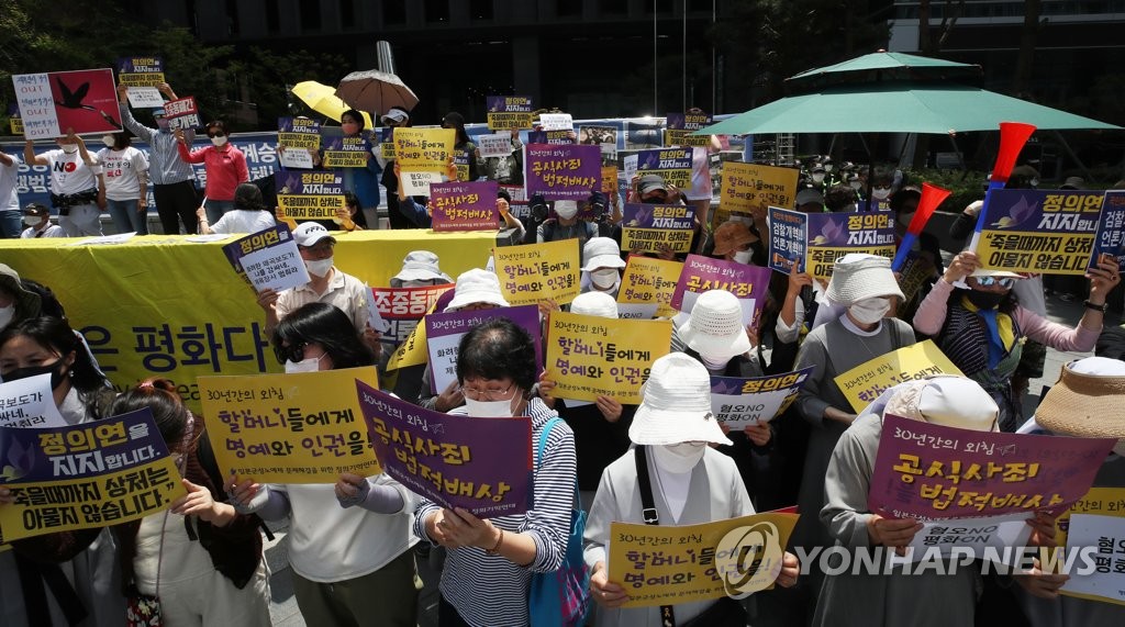 수요집회서 구호 외치는 참가자들