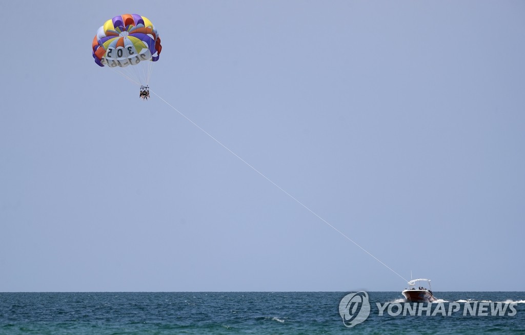 폐쇄 앞둔 해변에서 패러세일링하는 미국 시민들