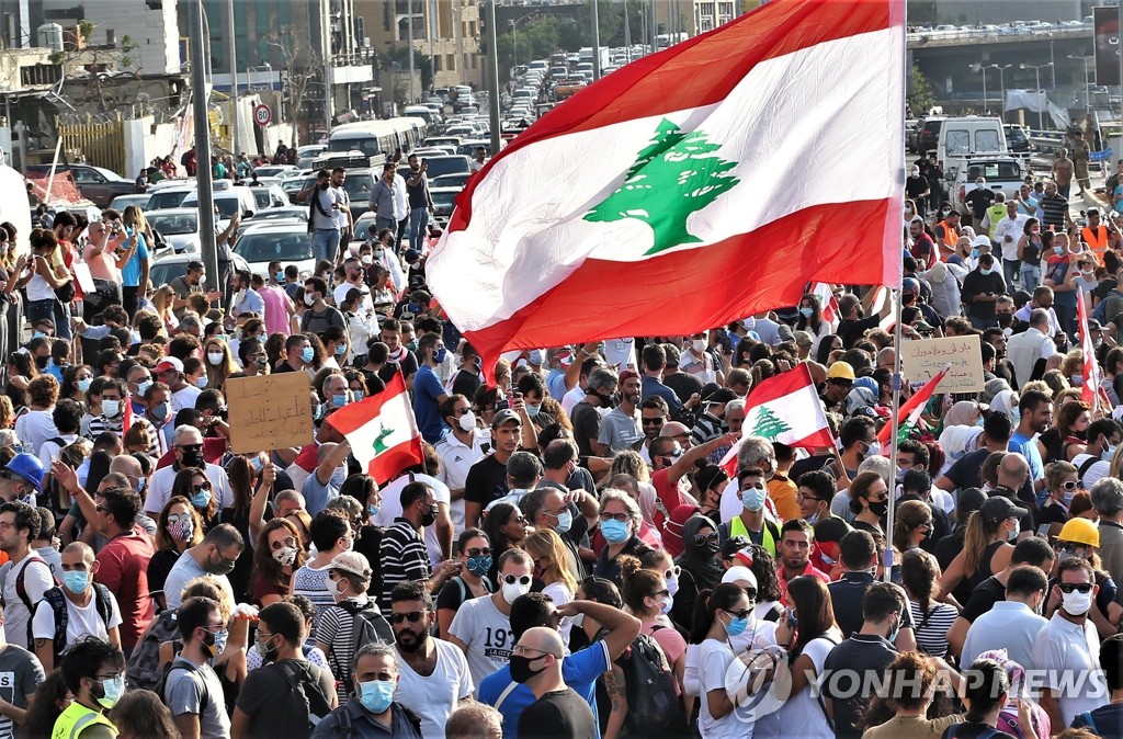 (베이루트 EPA=연합뉴스) 레바논 대규모 폭발참사 일주일을 맞은 11일(현지시간) 반정부 시위대가 폭발 현장인 베이루트 항구 근처에 모여 희생자들을 추모하고 있다. leekm@yna.co.kr
