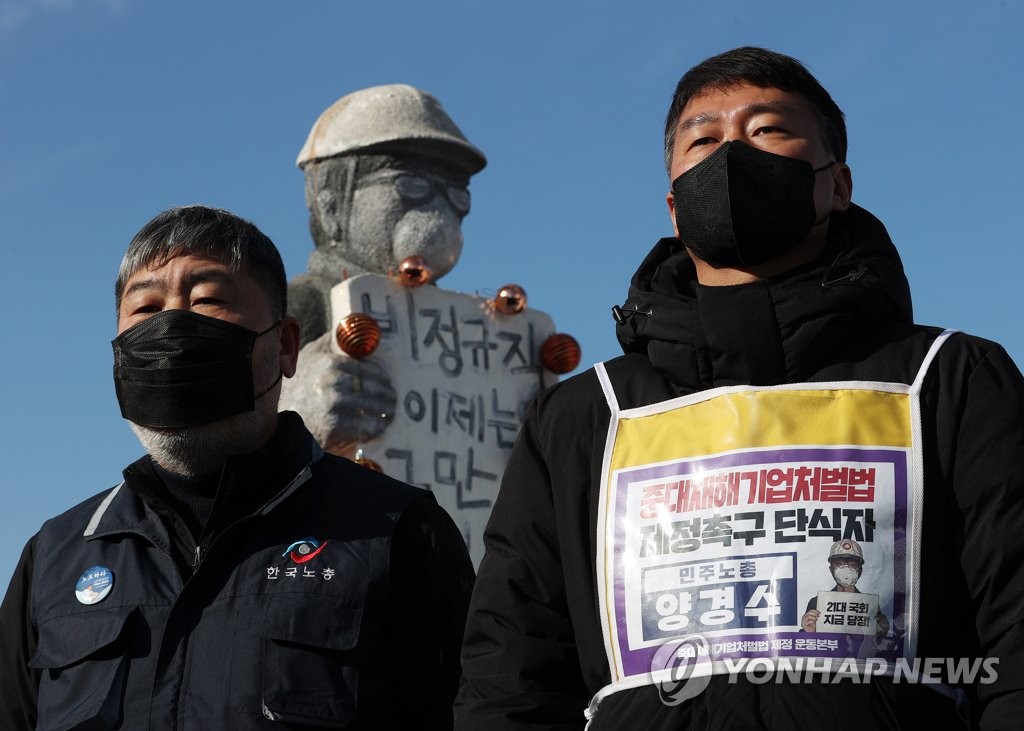 Heads of the two biggest umbrella labor unions hold a press conference in front of the National Assembly in Seoul on Jan. 5, 2021, calling for the parliamentary passage of legislation on punishing companies for severe workplace disasters. (Yonhap)