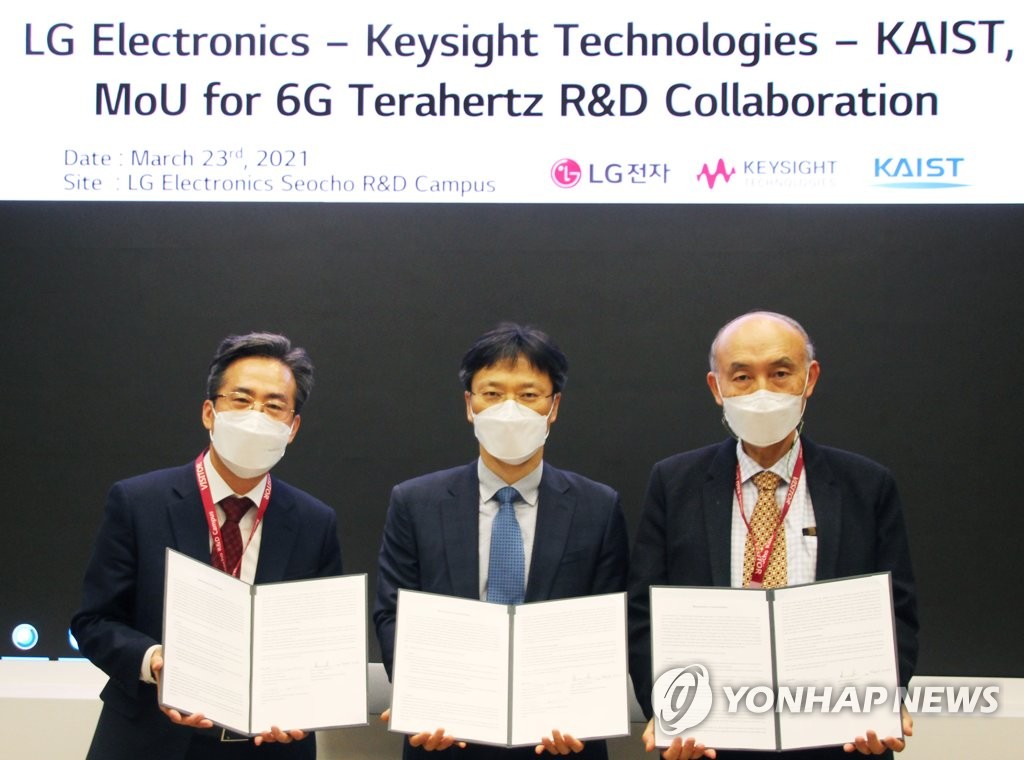 Des responsables de LG Electronics (au c.), de Keysight Technologies (à g.) et de l'Institut des sciences et technologies avancées de Corée (KAIST) posent pour une photo après avoir signé un accord de coopération pour le développement de la technologie 6G au centre R&D de LG à Séoul, le 23 mars 2021. (Photo fournie par LG Electronics. Revente et archivage interdits)