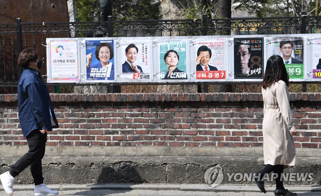 4·7 보궐선거 공식 선거운동 첫날이던 지난 3월 25일 오후 시민들이 서울 종로구 예술가의 집 울타리에 부착된 선거 벽보를 살펴보고 있다. [연합뉴스 자료사진]