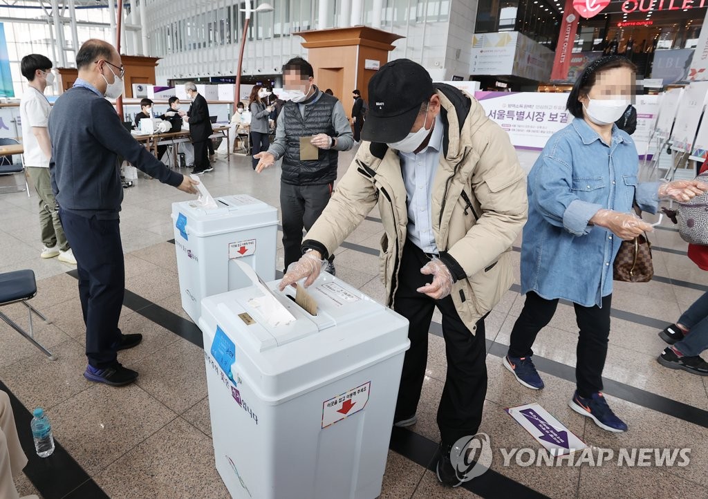 Voters cast ballots at a polling station in Seoul on April 2, 2021, the first day of two-day early voting for the April 7 Seoul mayoral by-election. (Yonhap)